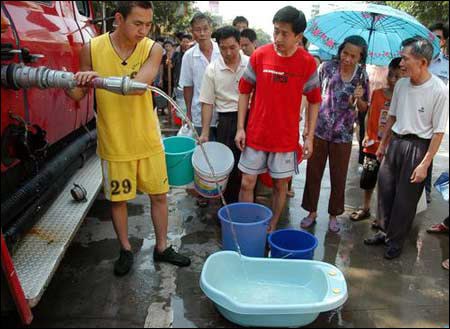 居民用澡盆与水桶等待取水